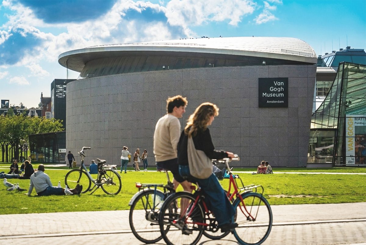 Pärchen auf Radtour in Amsterdam vor dem Van Gogh Museum